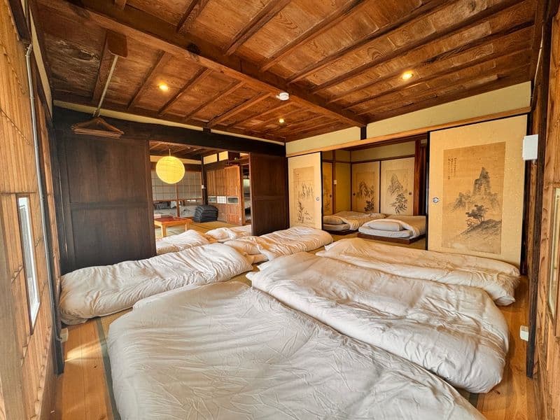 Futons laid side by side in a bedroom under an exposed-beam ceiling