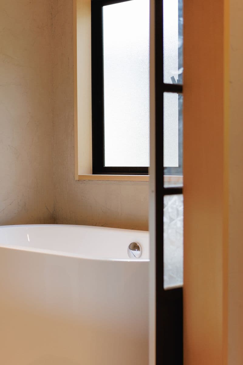 A white bathtub beside a frosted-glass window