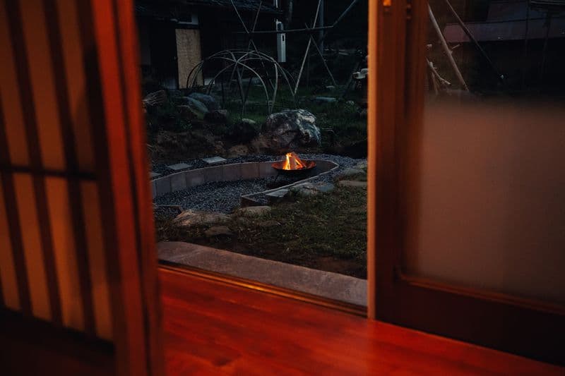 The garden fire pit burning, seen from inside the house