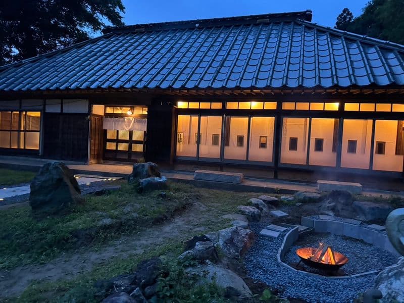 The house at dusk and the fire pit set in the garden