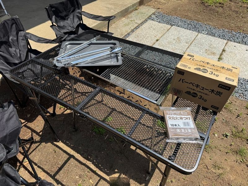 The barbecue grill table with charcoal, fire starter and tongs