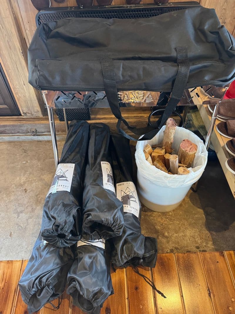 Folding chairs in carry bags and a bucket of firewood