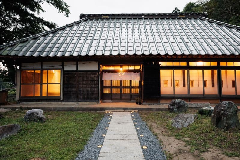 The main house at dusk, with lanterns along the stepping-stone path