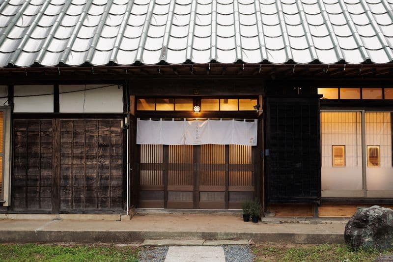 The lattice entrance door with a noren curtain hung above it